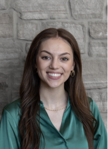 A woman in a green shirt smiling. 